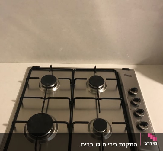 כיריים גז עם ארבעה מבערים וכפתורי שליטה
